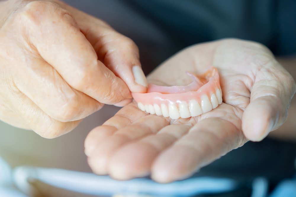 Close up in the hand of a pensioner removable dentures - Dentures in Georgina, ON