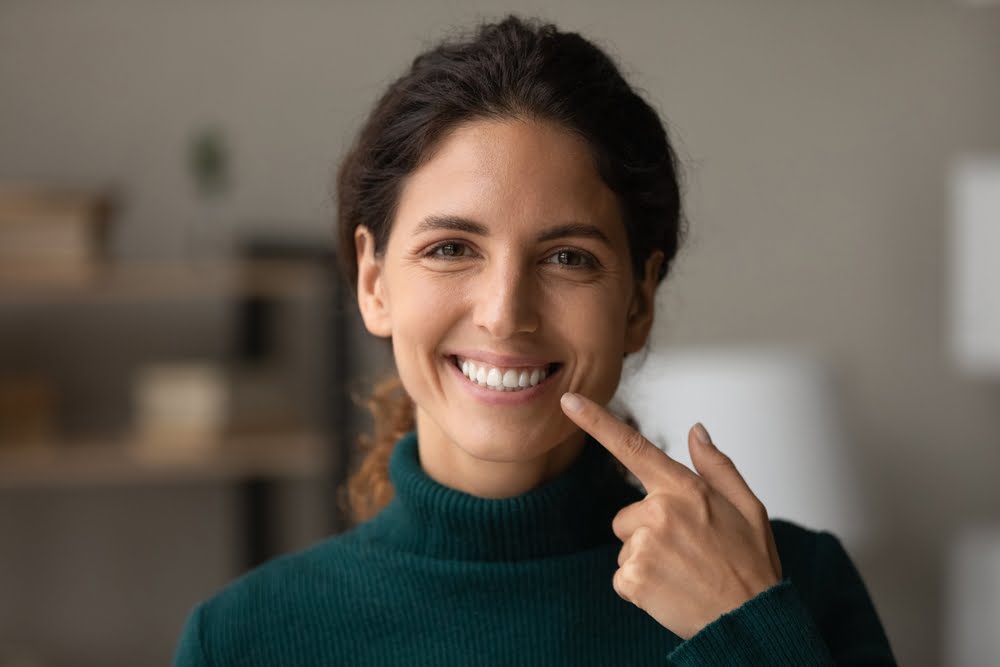 Woman pointing at her teeth - Dentures in Georgina, ON